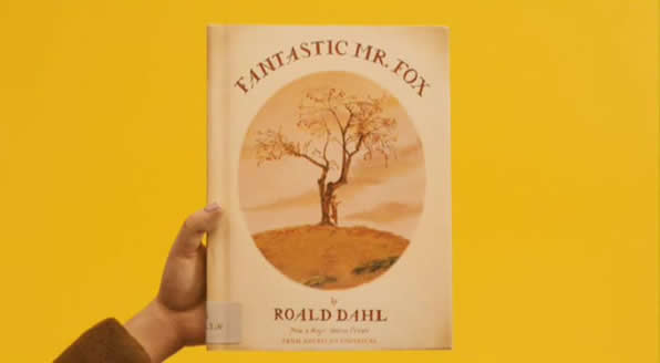 Mr. Fox holds up the cover of "The Fantastic Mr. Fox" by Roald Dahl
