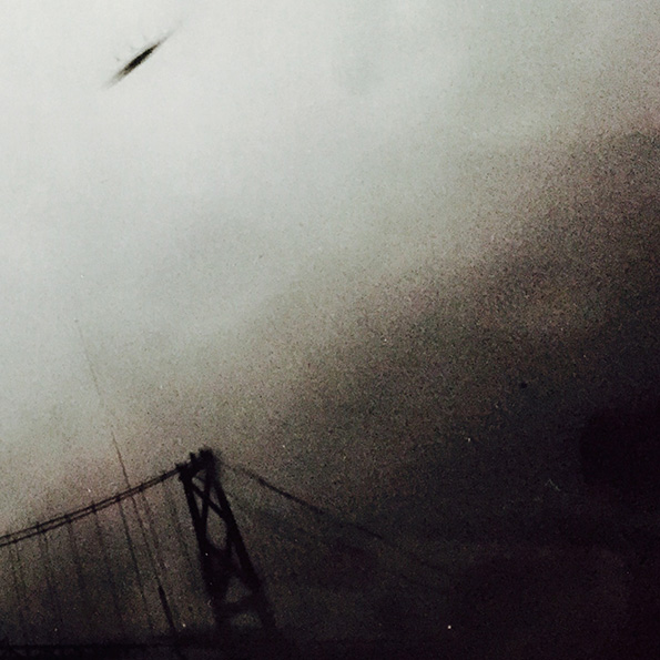 grainy black and white photo of a bridge and sky